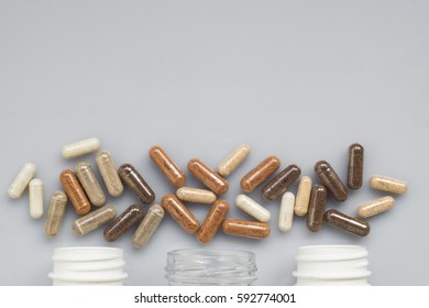 Medicinal capsule spill out of a three plastic bottles on a ligh