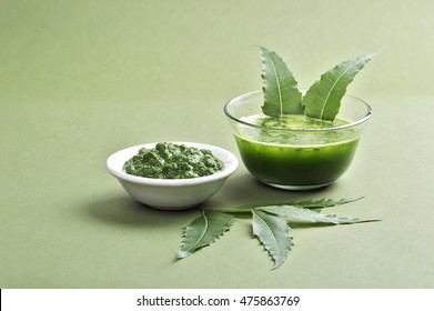 Medicinal Neem leaves paste and juice with leaves on green background 