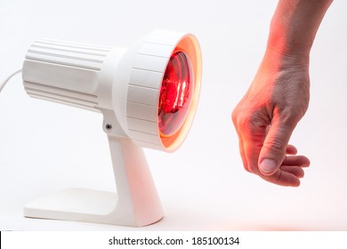 medicinal red-light-lamp radiating at a womans hand, isolated