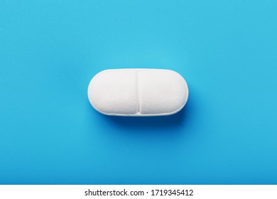 Medicinal tablet on a blue background, isolated.