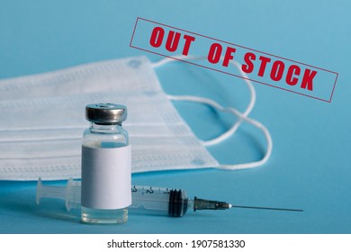 A Medicine Ampoule, A Medical Syringe, And Disposable Masks Are Close-up On A Blue Isolated Background. The Concept Of A Shortage Of Vaccines Against Infection, Influenza, And Coronavirus.