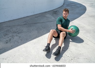 Medicine Ball Exercise Russian Twist Man. Abs Workout - Fitness Athlete Working Out Doing Exercises Training Oblique Muscles On Outdoor Floor.