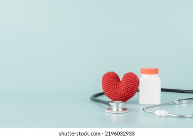 Medicine Bottle And Pill With Stethoscope And Red Heart Shape Concept Of Health Care And Medical. Aspirin Bottle And Stethoscope And Yarn Heart On Light Blue Background.