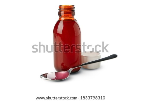 Medicine bottle and spoon with syrup isolated on white background