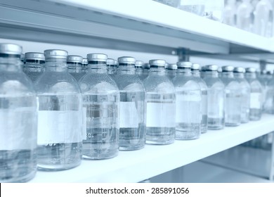 Medicine Bottles In Row On Storage Shelf In Hospital