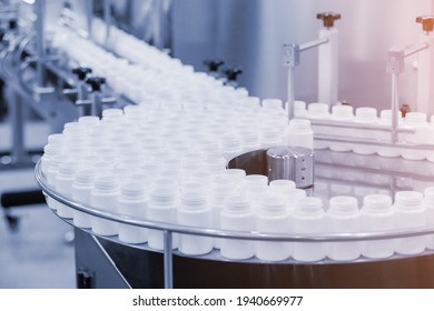 Medicine bottles transfer on line conveyor in pharmaceutical industry. Industrial Machine for quality of medical product in line conveyor processing. Industrial and factory technology concept.