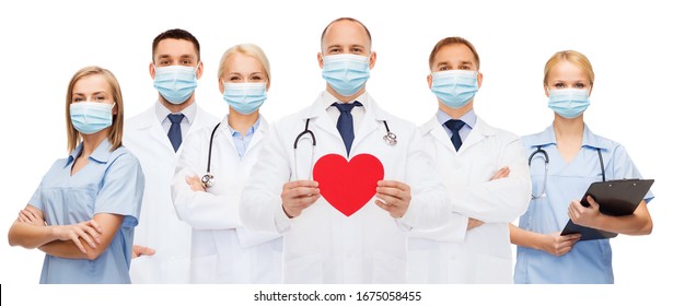 Medicine, Cardiology And Healthcare Concept - Group Of Doctors Wearing Protective Medical Masks With Red Heart And Stethoscopes Over White Background