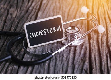 Medicine concept. Blackboard with word menopause and cholesterol on wooden background