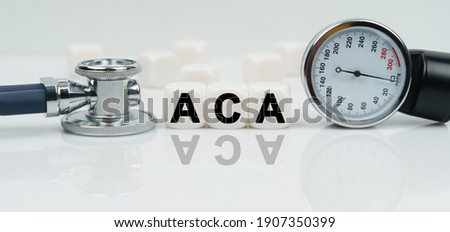 Medicine concept. On a reflective white surface lies a stethoscope and cubes with the inscription - ACA Imagine de stoc © 