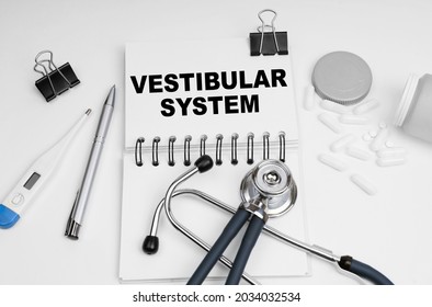 Medicine concept. On the table are a stethoscope, pills, a thermometer and a notebook with the inscription - Vestibular System