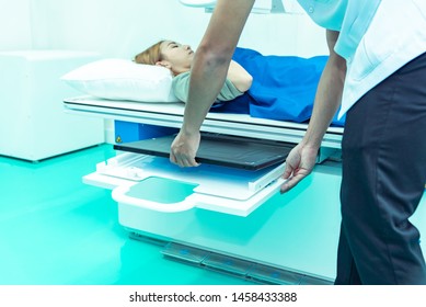 Medicine concept ,Technician Doctor male radiologist with colleague setting up machine to take female patient in x-ray room - Powered by Shutterstock