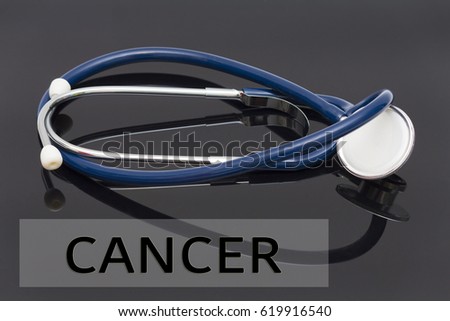 Medicine concept. Word of 'cancer' and stethoscope on black background.