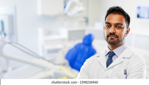 Medicine, Dentistry And Healthcare Concept - Indian Male Dentist In White Coat Over Dental Clinic Office Background