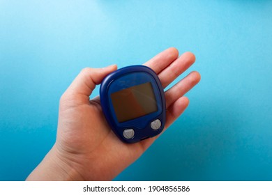 Medicine, Diabetes, Glycemia, Health Care And People Concept - Close Up Of Man Checking Blood Sugar Level By Glucometer And Test Stripe At Home