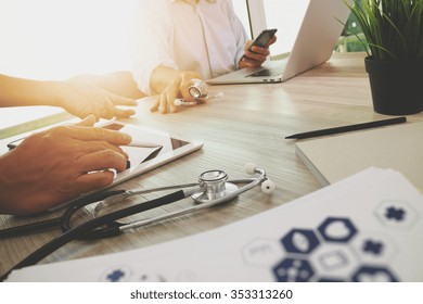 Medicine doctor hand working with modern computer and digital tablet with his team on wooden desk as medical concept

 - Powered by Shutterstock