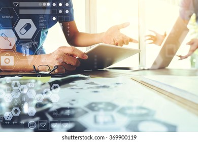 Medicine doctor hand working with modern computer and digital tablet and diagram with his team on wooden desk as medical concept
 - Shutterstock ID 369900119