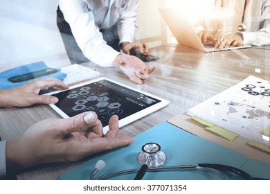 Medicine Doctor Hand Working With Modern Computer And Digital Pro Tablet With His Team With Graphics Medical Diagram On Wooden Desk,sun Flare Effect          