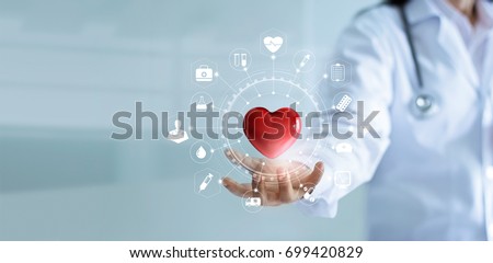 Medicine doctor holding red heart shape in hand with medical icon network connection modern virtual screen interface, service mind and medical technology network concept