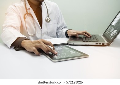 Medicine Doctor Working With Computer Notebook And Digital Tablet  At Desk In The Hospital