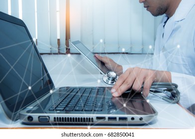 Medicine doctor working with computer notebook and digital tablet at desk in the hospital - Shutterstock ID 682850041