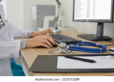 Medicine doctor's working table. Doctor's workspace working at computer and typing electronic medical record sitting near stethoscope and clipboard. Medicine concept. Focus on stethoscope. Close up. - Shutterstock ID 2155713289