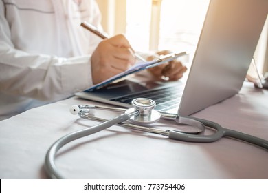 Medicine doctor's writing on laptop in medical office.Focus stethoscope on foreground table in hostpital.Stethoscope is acoustic medical device for auscultation,listening internal sounds of human body - Powered by Shutterstock