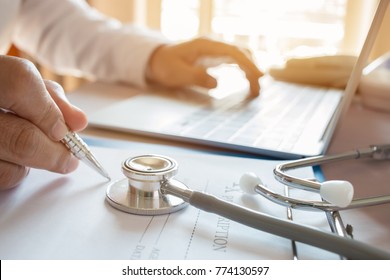Medicine doctor's writing on laptop in medical office.Focus stethoscope on foreground table in hostpital.Stethoscope is acoustic medical device for auscultation,listening internal sounds of human body