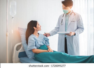 Medicine And Health Care Concept.  Asian Doctor Is Taking Care Patient Woman In Hospital.doctor Or Nurse Wear Protection Mask Checking And Takecare Infection People From Covid-19 .