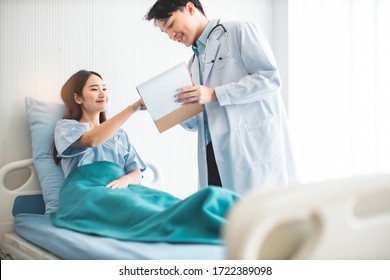 Medicine And Health Care Concept.  Asian Doctor Is Taking Care Patient Woman In Hospital.doctor Or Nurse Wear Protection Mask Checking And Takecare Infection People From Covid-19 .