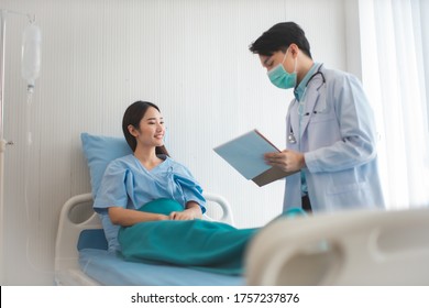 Medicine And Health Care Concept.  Asian Doctor Is Taking Care Patient Woman In Hospital.doctor Or Nurse Wear Protection Mask Checking And Takecare Infection People From Covid-19 .