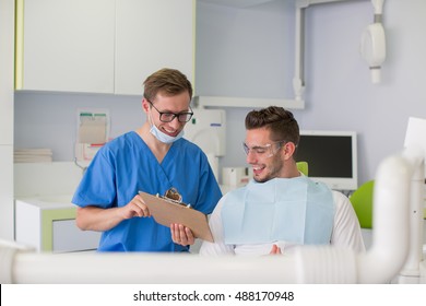 Medicine And Health Care Concept - Happy Male Dentist With Patient Talking At Dental Clinic Office.