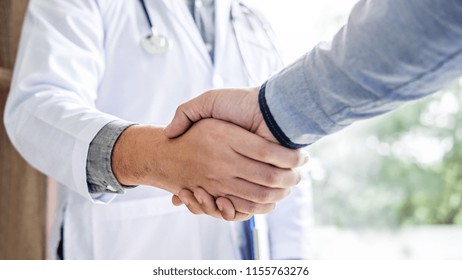 Medicine And Health Care Concept, Professional Male Doctor In White Coat Handshake With Patient After Successful Recommend Treatment Methods.