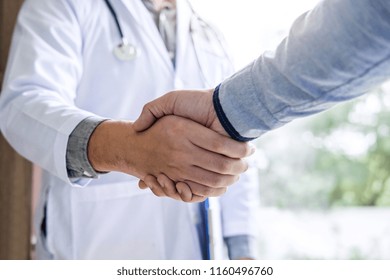 Medicine And Health Care Concept, Professional Male Doctor In White Coat Handshake With Patient After Successful Recommend Treatment Methods.