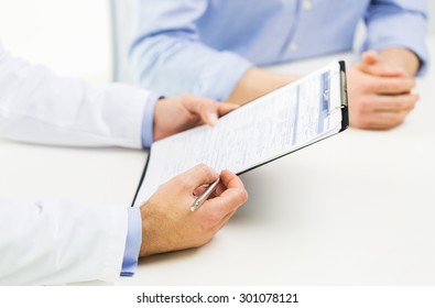 Medicine, Health Care, People And Prostate Cancer Concept - Close Up Of F Male Doctor And Patient Hands With Clipboard