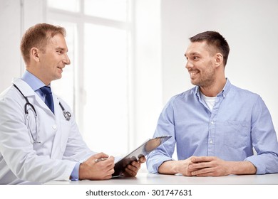 Medicine, Health Care, People And Prostate Cancer Concept - Happy Male Doctor With Clipboard And Patient Meeting And Talking At Hospital