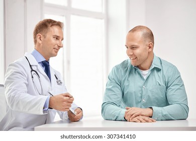 Medicine, Health Care, People And Prostate Cancer Concept - Happy Male Doctor With Clipboard And Patient Meeting And Talking At Hospital