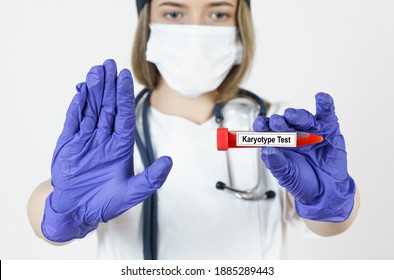 Medicine and health concept. The doctor holds in his hands a test tube with blood tests for the Karyotype, with the other hand he makes a gesture - stop.