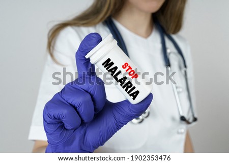 Medicine and health concept. The doctor holds a medicine in his hands, which says - STOP MALARIA