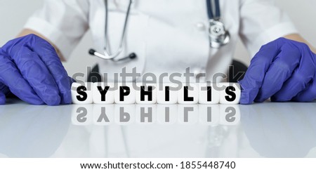 Medicine and health concept. The doctor put together a word from cubes SYPHILIS