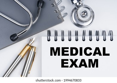 Medicine And Health Concept. On The Table Are A Stethoscope, A Pen And A Notebook With The Inscription - MEDICAL EXAM