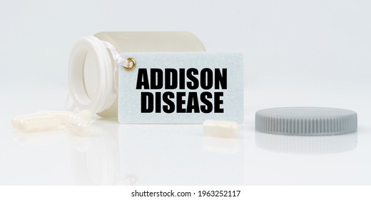 Medicine and health concept. On a white reflective background, there are pills and a jar of drugs with a tag that says - ADDISON DISEASE