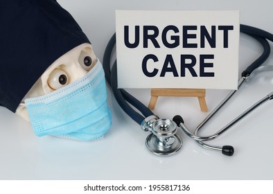 Medicine And Health Concept. Skull In Mask And Cap, Stethoscope And Easel With Canvas On Which It Is Written - URGENT CARE