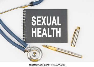 Medicine And Health. On A White Background Lie A Stethoscope, A Pen And A Notebook With The Inscription - SEXUAL HEALTH