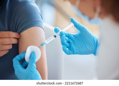 Medicine, health and patient with a covid vaccine from a doctor at a hospital during a pandemic. Closeup of a healthcare worker doing a medical antibody treatment injection at a medicare clinic. - Shutterstock ID 2211672687