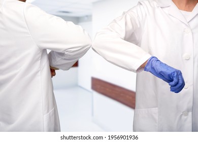 Medicine, Health Protection And Healthcare Concept - Close Up Of Doctors Make Elbow Bump Greeting Gesture Over Corridor At Hospital On Background