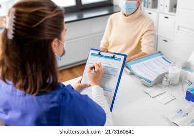 Medicine, Health And Vaccination Concept - Doctor With Clipboard And Senior Woman In Mask At Hospital