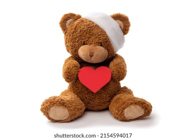 medicine, healthcare and childhood concept - teddy bear toy with bandaged head holding red heart on white background