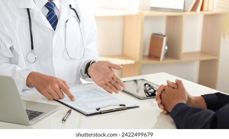 Medicine and healthcare concept. doctor and patient discussing current health examination while sitting in clinic. Medical care, insurance, prescription, paper work. annual physical examination.  - Powered by Shutterstock