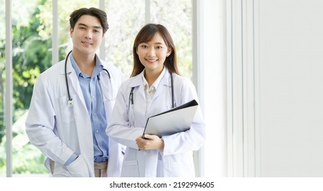 Medicine and healthcare concept : Happy and cheerful asian doctors, Male and Female holding files with stethoscope and smiling in lobby of hospital. - Powered by Shutterstock