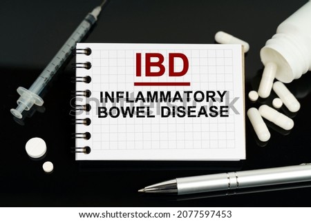 Medicine and healthcare concept. On the black surface are pills, a syringe and a notebook with the inscription - IBD-Inflammatory Bowel Disease Stock photo © 